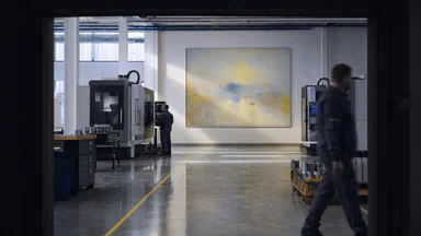 Isembard manufacturing floor with CNC machines and two workers